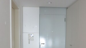 Une pièce avec un plancher en bois, une porte blanche et une armoire blanche.