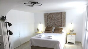 A neatly arranged bedroom with a bed, bedside tables, a floor lamp, and a decorative wall piece. - ALBIR house ideally located - 100M from the sea - perfect for 2 to 8 people (Albir)