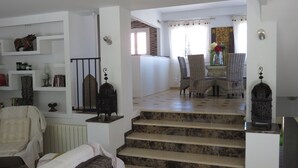 A staircase leading to a dining area with wicker chairs and a table. - ALBIR house ideally located - 100M from the sea - perfect for 2 to 8 people (Albir)