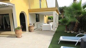 A covered outdoor area with a patio, white lounge chairs, and potted plants. - ALBIR house ideally located - 100M from the sea - perfect for 2 to 8 people (Albir)