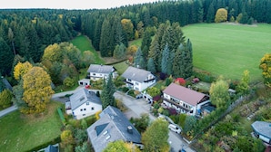 Un quartier résidentiel composé de plusieurs maisons, entouré d’une forêt dense.