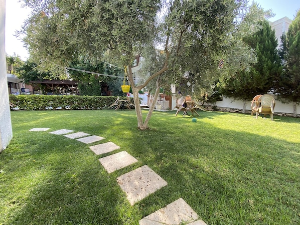 A well-maintained garden with a stone pathway leading to a seating area.