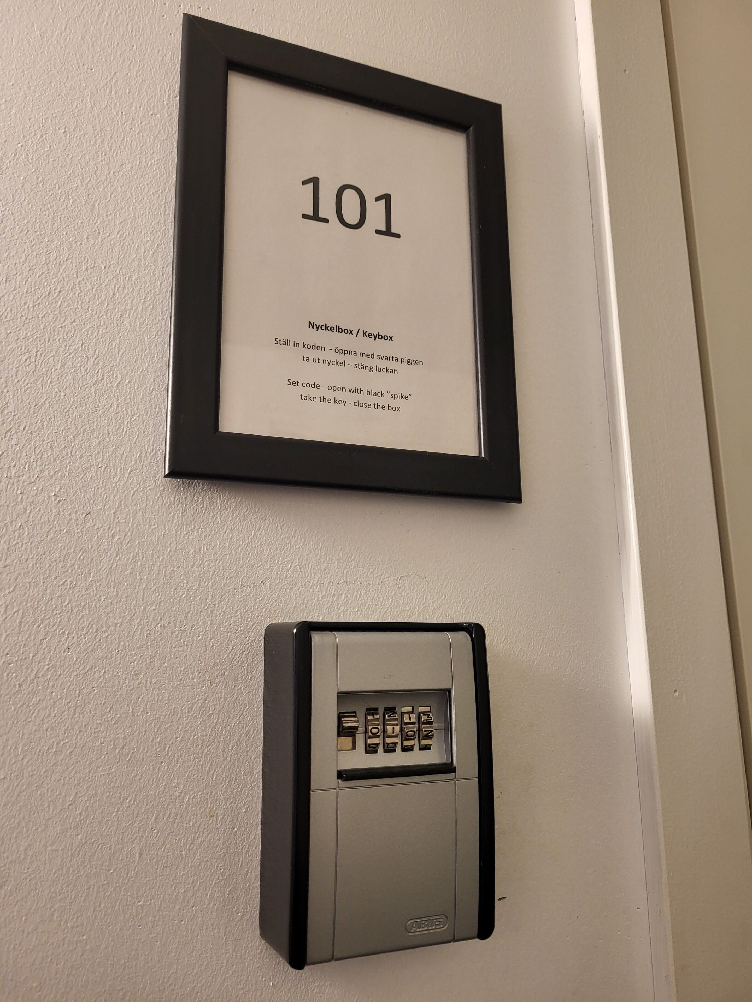 A framed number '101' with instructions for a keybox and a keypad device below it.