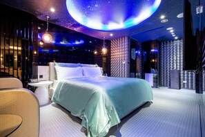 A modern bedroom with a large bed, a round table, and a chair. - Aurora Motel (Taichung)