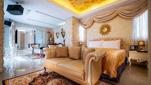 A luxurious bedroom with a large bed, a sofa, and a chandelier. - Aurora Motel (Taichung)