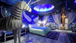 A luxurious bedroom with a large bed, a unique sculpture, and a starry room design. - Aurora Motel (Taichung)