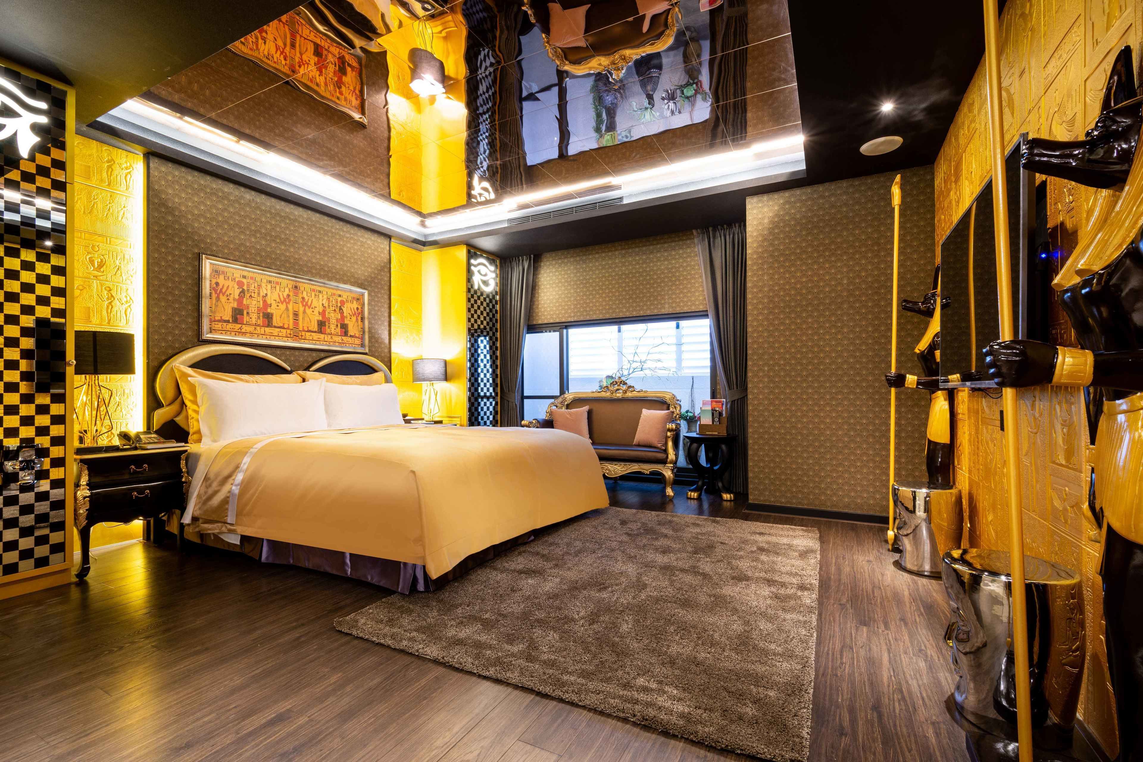Een ruime slaapkamer met een groot bed, een zithoek en een badkamer met een uniek design.