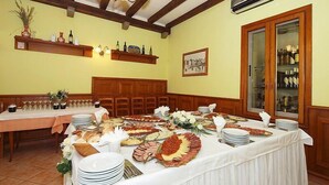 A banquet hall with a long table set for a meal, wooden beams on the ceiling, and a wall-mounted air conditioning unit. - B&B Kvarner (Labin)