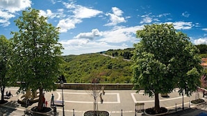 A public square with trees, benches, and a road leading to a hill. - B&B Kvarner (Labin)