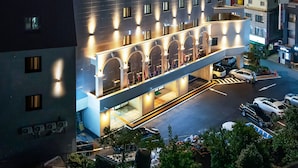 A modern hotel with a multi-story structure, a covered entrance, and a parking area. - Hotel Artheim (Gwangju)