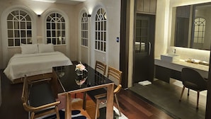 A modern hotel room with a dining area, a bed, and a bathroom with a large mirror. - Hotel Artheim (Gwangju)