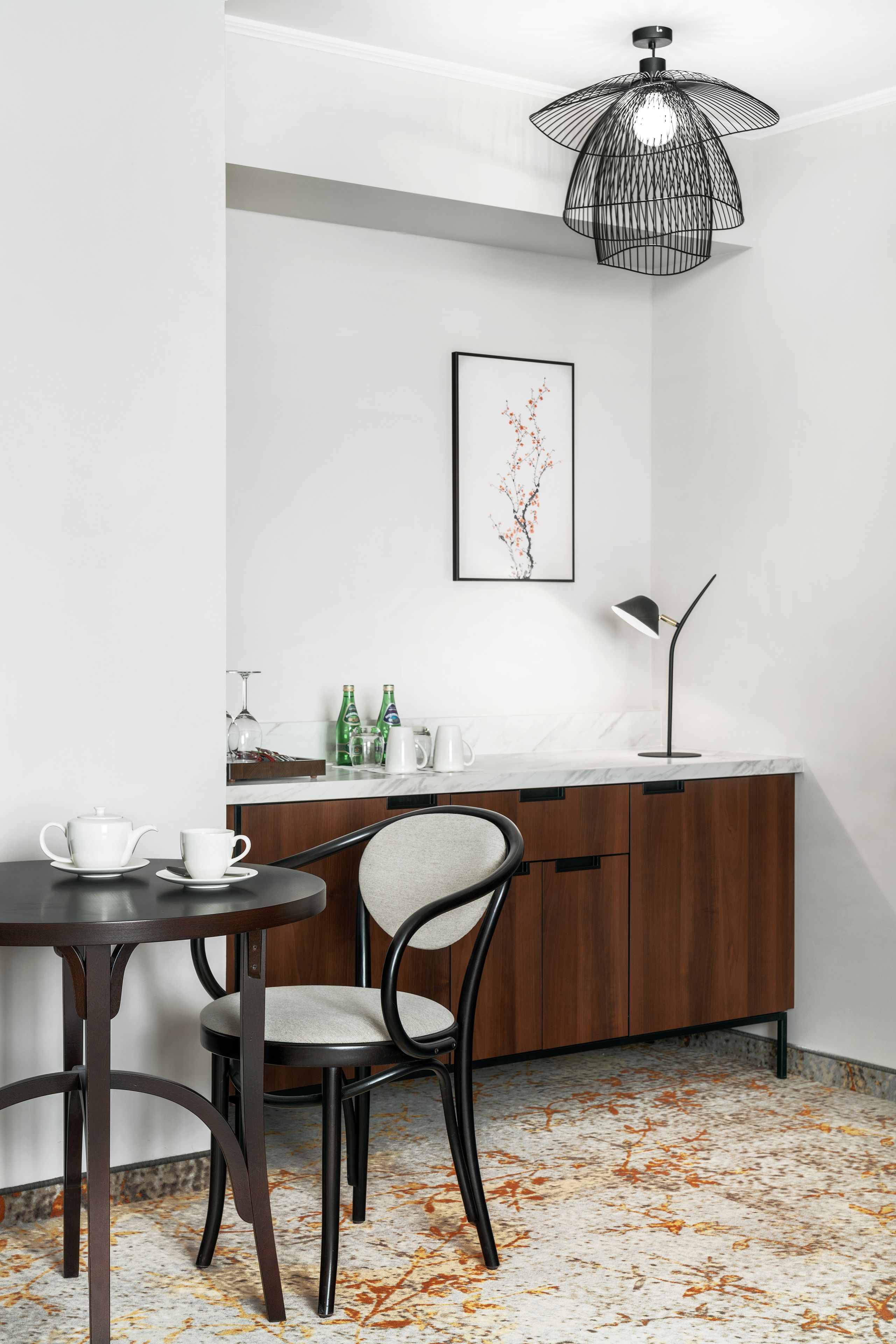 A dining area with a table, chairs, a cabinet, and a pendant light.