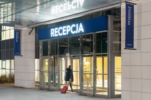 A reception area with glass doors and a blue sign.
