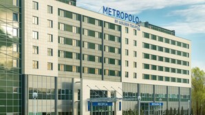 Un moderno edificio de hotel con fachada de vidrio, varios pisos y un área de recepción que dice 'RECEPCIA'.