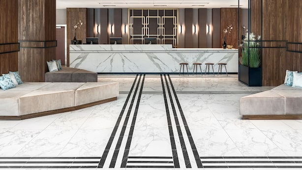 Un vestíbulo moderno con un mostrador de recepción de mármol, zonas de estar e instalación decorativa.