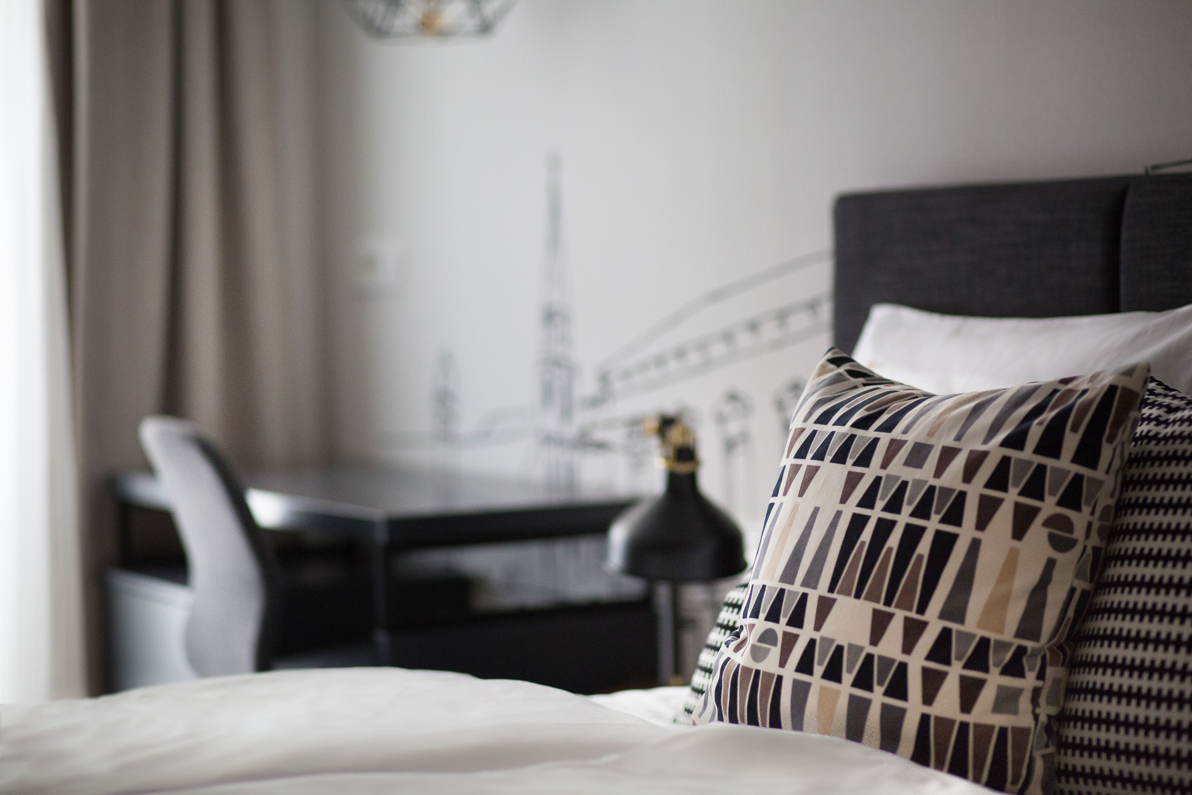 Une chambre d’hôtel avec un lit, un bureau et une chaise.