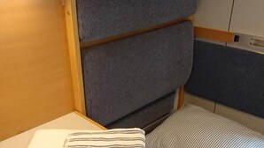 Un letto a castello con testiera e un letto inferiore. C'è un asciugamano piegato sul letto inferiore.