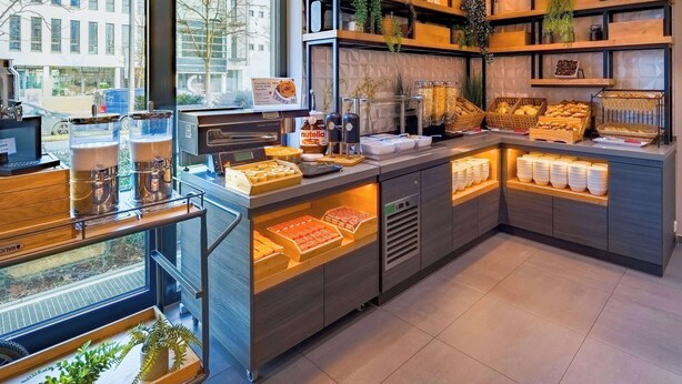 Un bufé de desayuno con diversos alimentos y una estación de café.