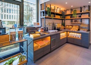 Un bufé de desayuno con diversos alimentos y una estación de café.