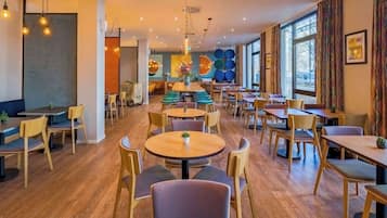 Un restaurante espacioso con varias zonas de estar, mesas redondas y cabinas.