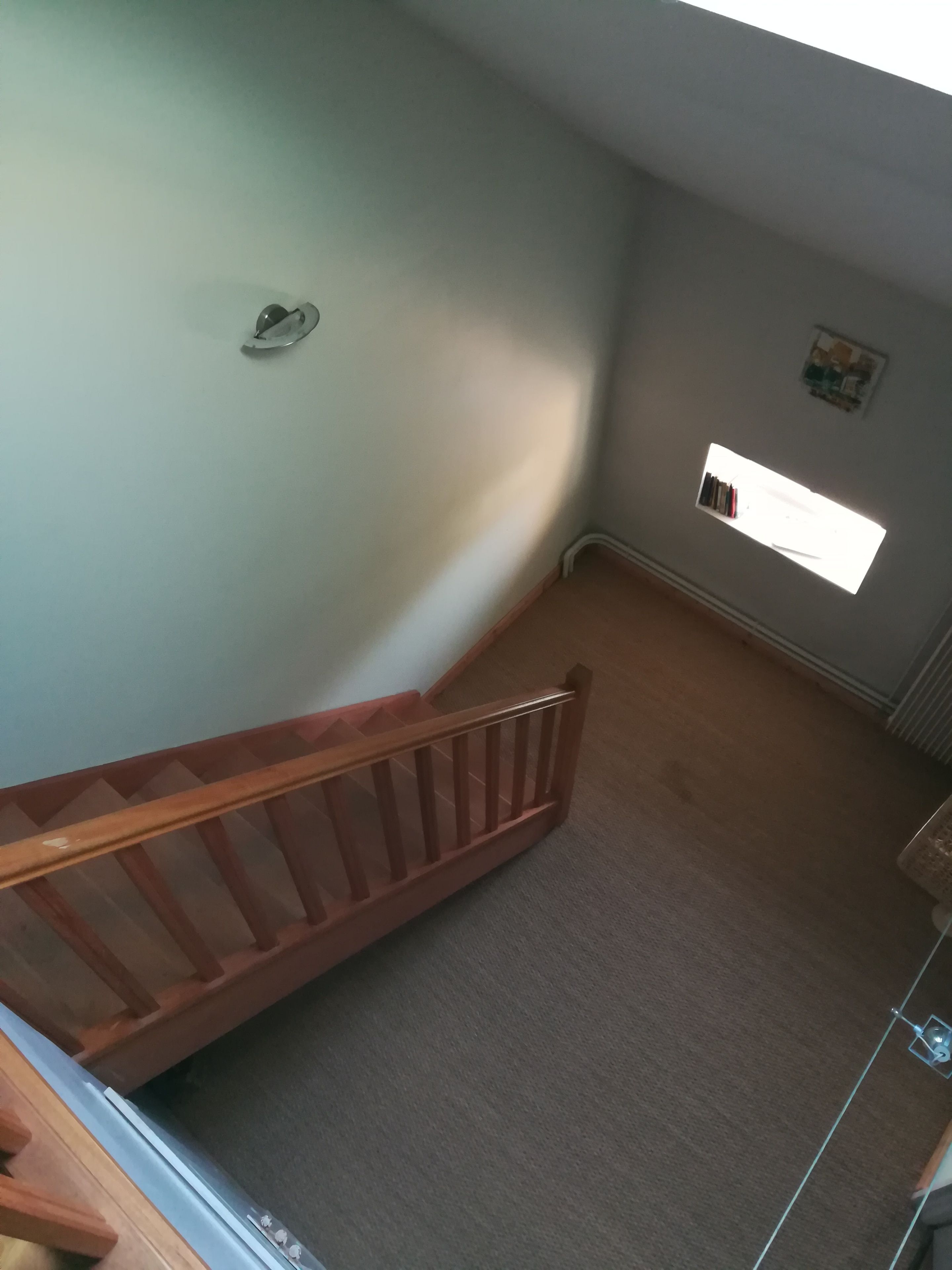 Eine Treppe mit Holzgeländer, die zu einer Zwischenebene führt.
