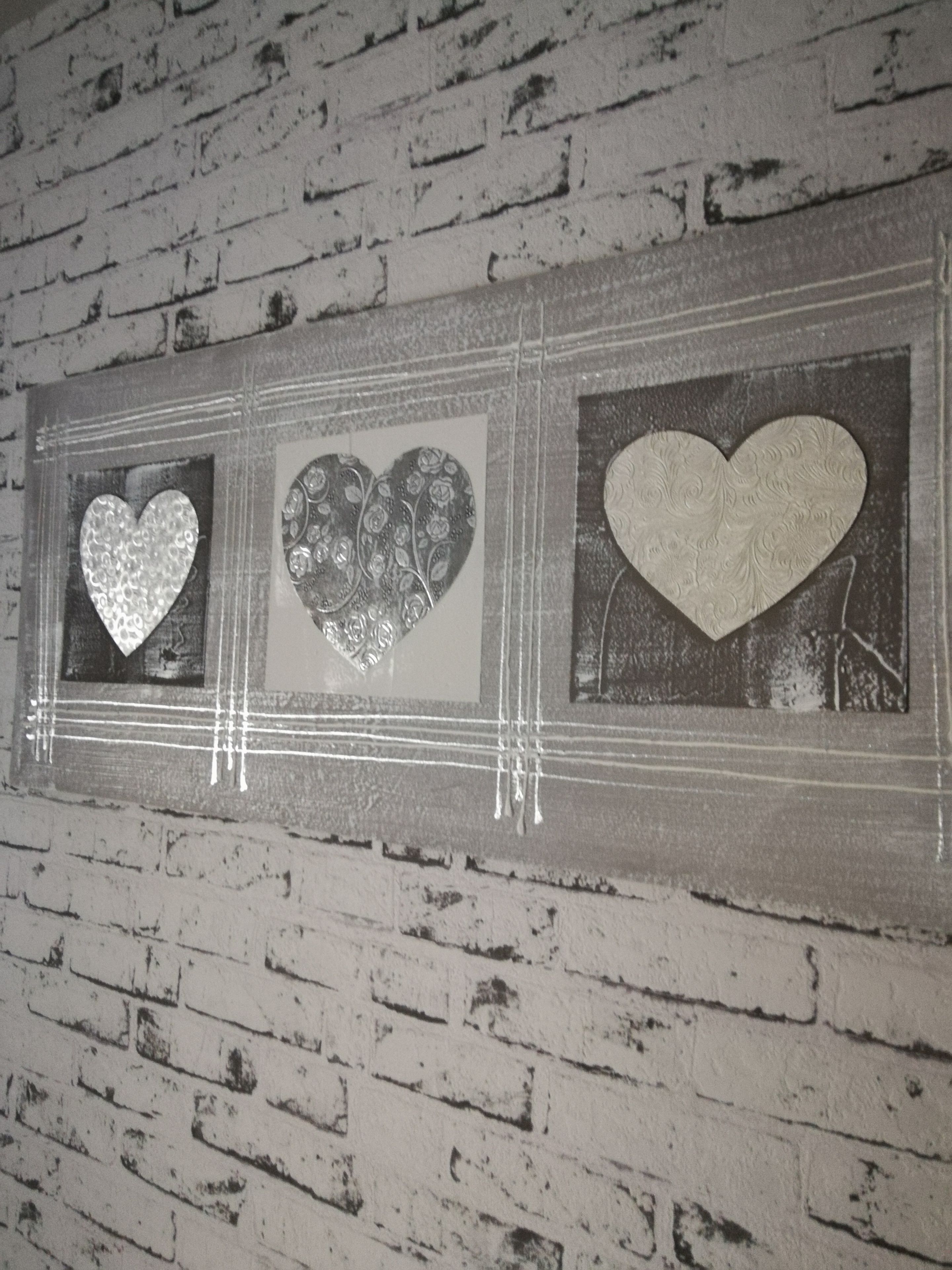A wall with three heart-shaped decorations in a rectangular frame.