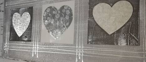 A wall with three heart-shaped decorations in a rectangular frame.