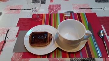 Una mesa con un plato de comida, una taza y cubiertos.
