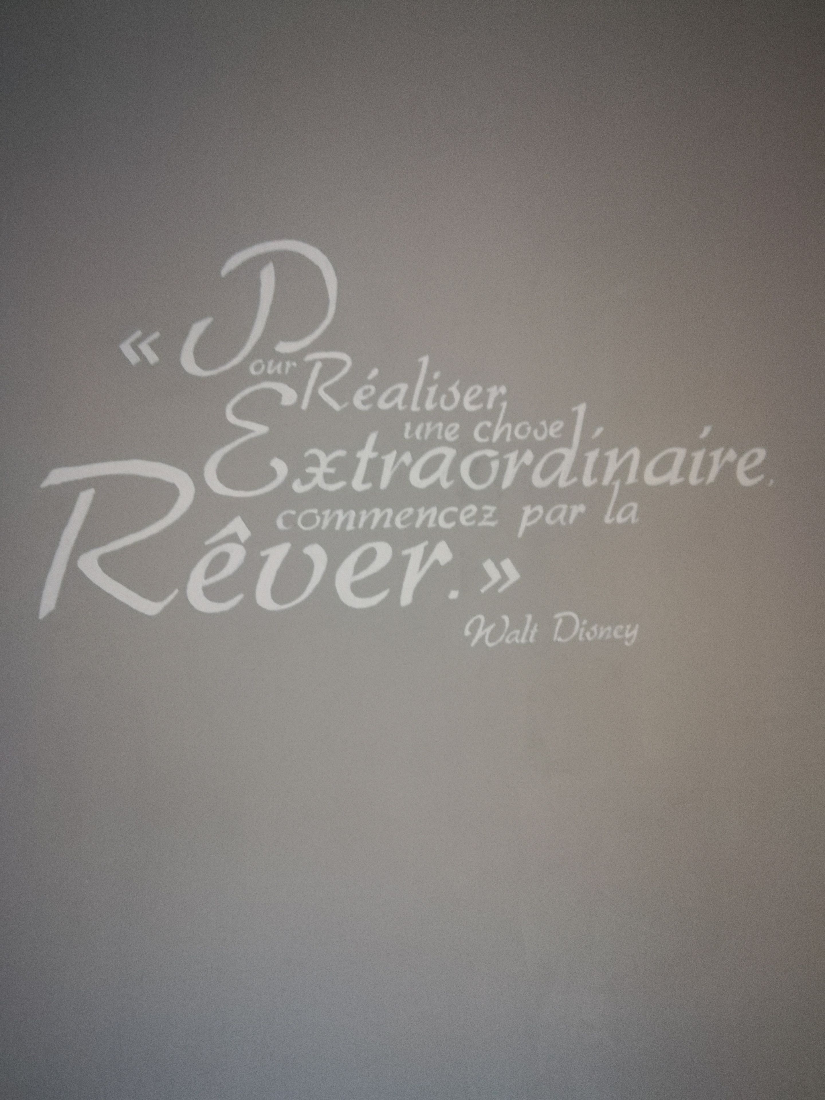 Une citation de Walt Disney sur un mur gris.
