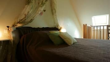 Un dormitorio con cama a dosel, una mesita de noche y una ventana con vistas al exterior.