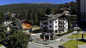A multi-story hotel with balconies, a restaurant, and a view of a mountain. - Du Parc Hotel (Sauze d'Oulx)
