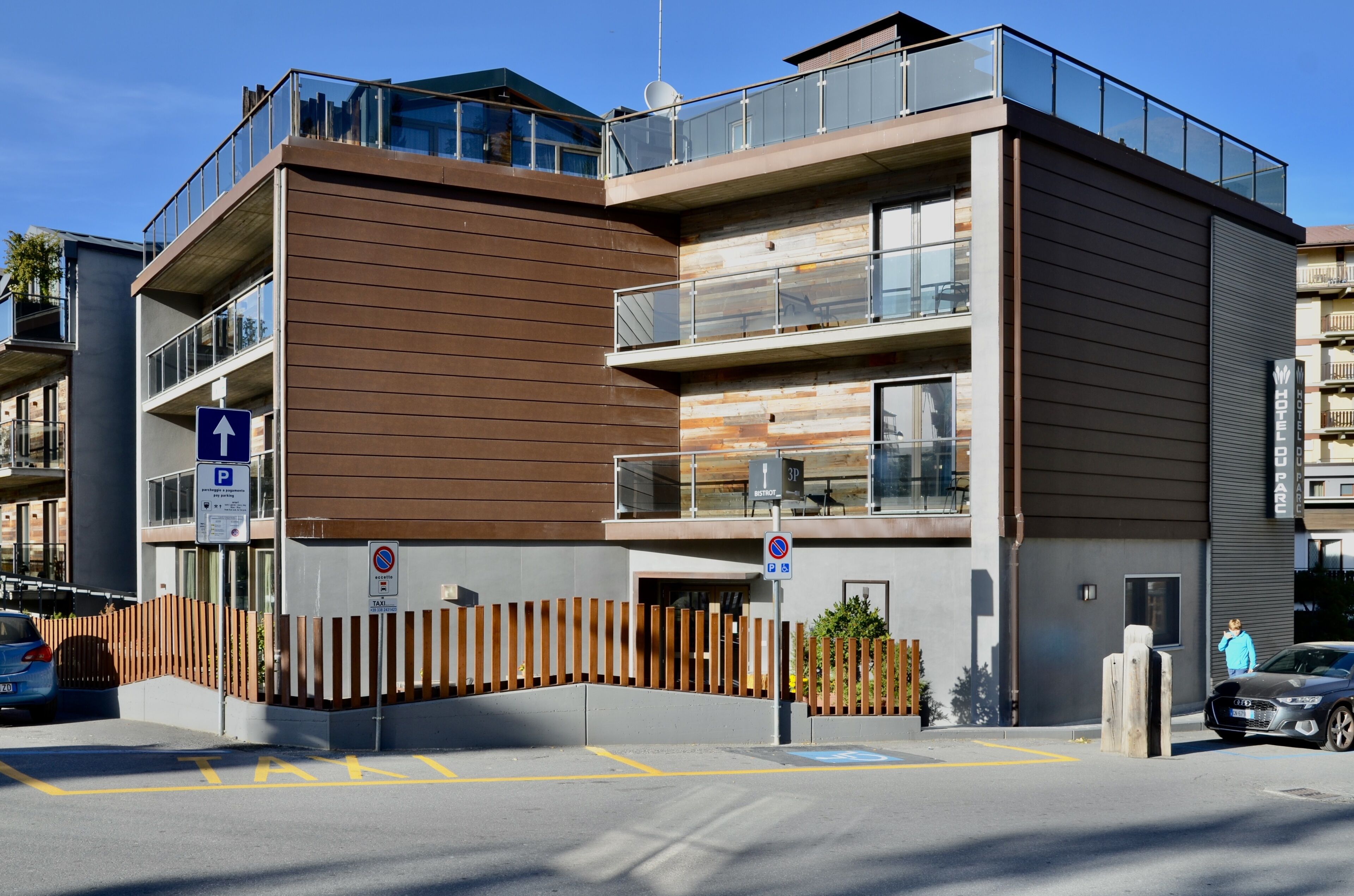 Un edificio moderno de varios pisos con techo plano, ventanas grandes y balcones.