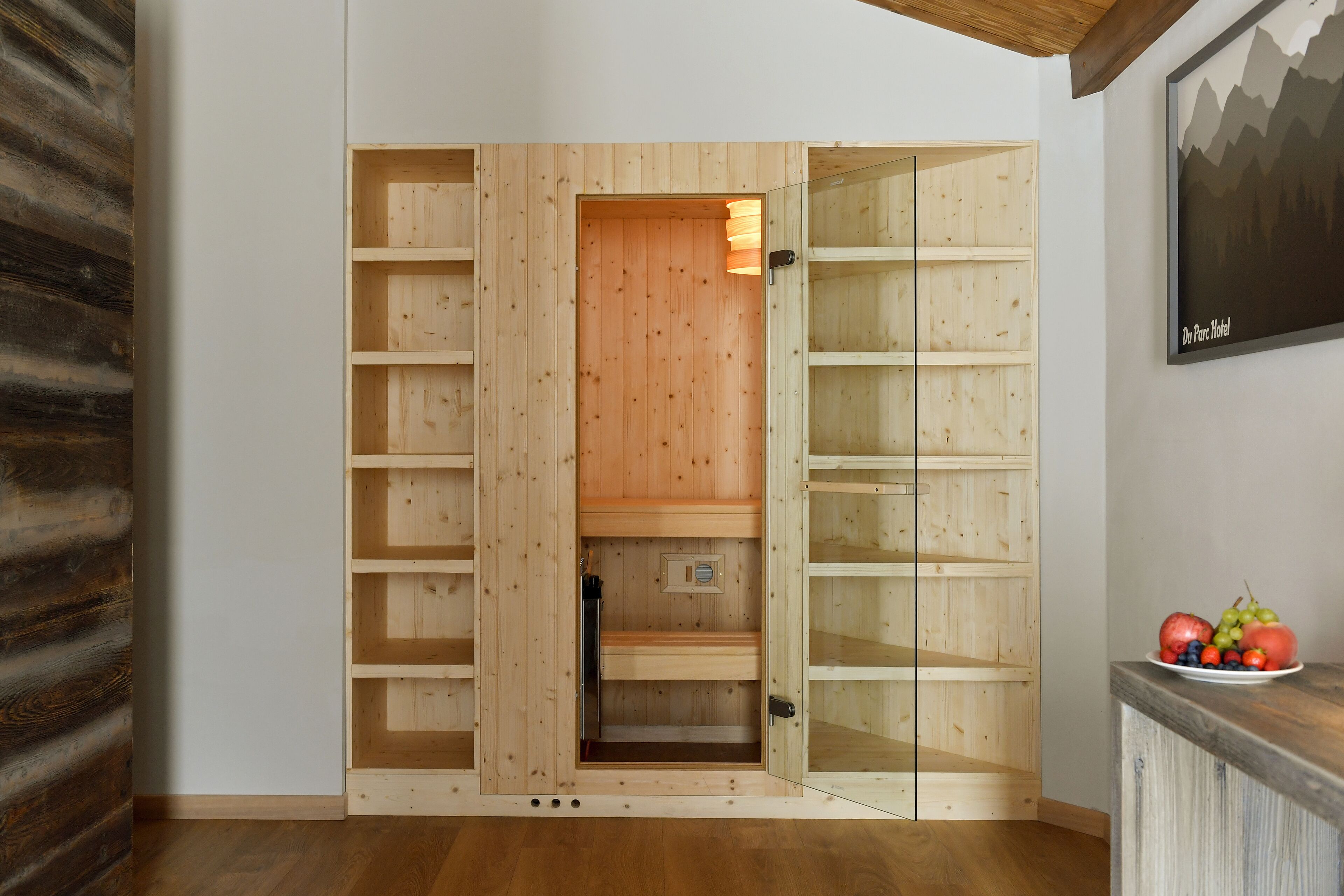 A wooden wardrobe with multiple shelves and a glass door.