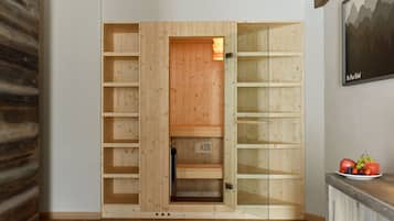 A wooden wardrobe with multiple shelves and a glass door.