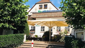 A Landhotel with a white facade, a brown roof, and a sign for a restaurant. - Landhotel Weserblick (Beverungen)