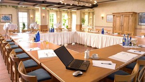 A conference room with a long table, chairs, a laptop, and documents. - Landhotel Weserblick (Beverungen)