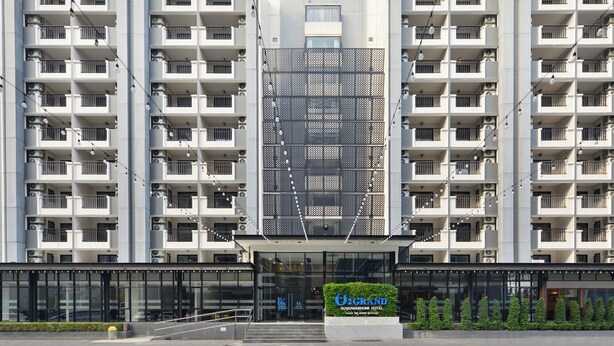 A multi-story hotel with balconies, a central atrium, and a sign for 'U2GRAND Suvarnabhumi Hotel'.