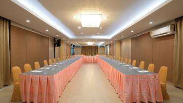 Un salón de conferencias con una mesa larga, sillas y un equipo de aire acondicionado.