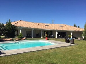 Una piscina al aire libre de temporada, sombrillas
