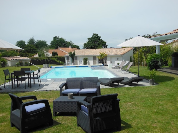 Una piscina al aire libre de temporada, sombrillas