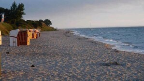 Una playa con estructuras de madera, probablemente cabañas, a lo largo de la orilla.