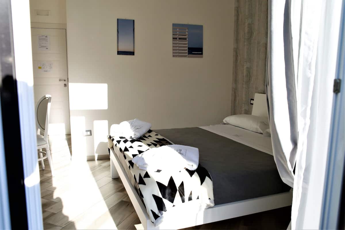 A room with a bed, a chair, and a desk.