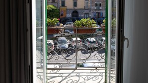 A balcony with a view of a cityscape, including buildings and parked cars. - Hermes Rooms for tourists (Naples)