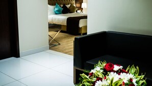 Una habitación de hotel con una cama, una mesita de noche, una lámpara y un arreglo floral.