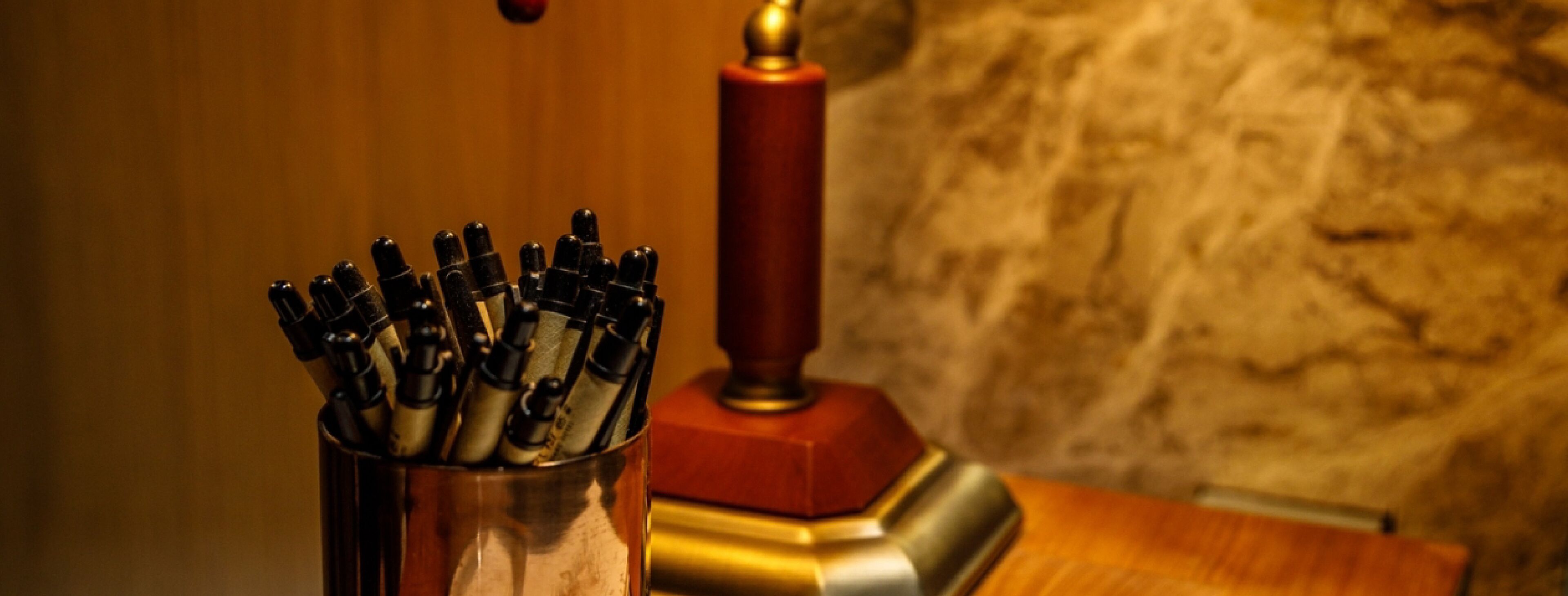 A metal container holding several pens.