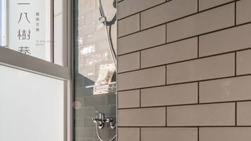 Un bagno con doccia e rivestimento in piastrelle.