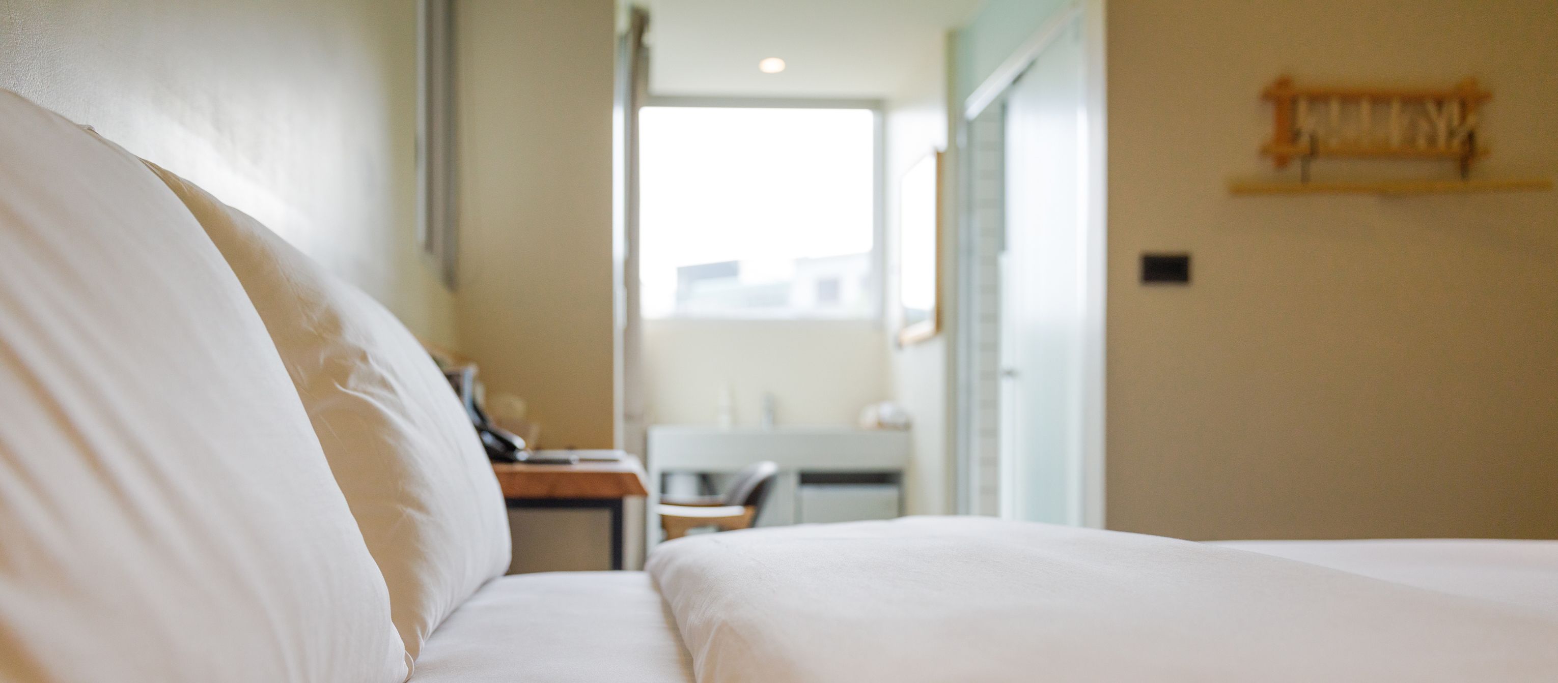 A hotel room with a bed, a desk, and a chair.