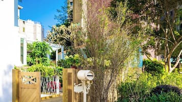 A gated entrance with a mailbox, lush greenery, and a building in the background.