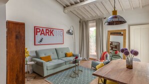 A living room with a sofa, a coffee table, a dining table, and a chandelier. - Apartments Florence San Lorenzo Terrace (Firenze)