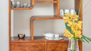 A wooden cabinet with shelves, a drawer, and a vase with flowers. - Apartments Florence San Lorenzo Terrace (Firenze)